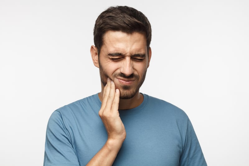 Man holding jaw in pain